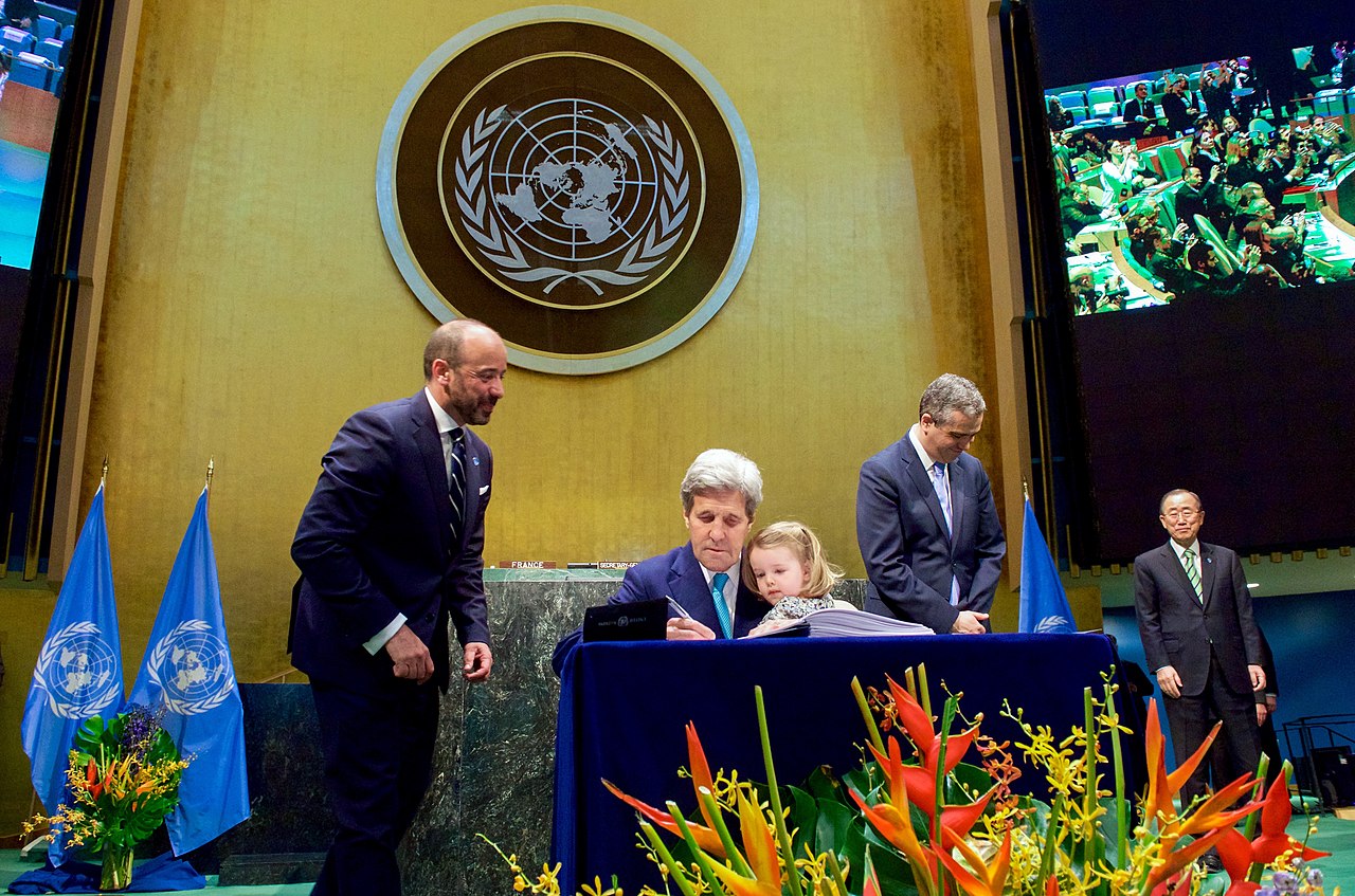 U.S. Secretary of State John Kerry signs the Paris Agreement with 2-year-old granddaughter Isabelle Dobbs-Higginson on his lap