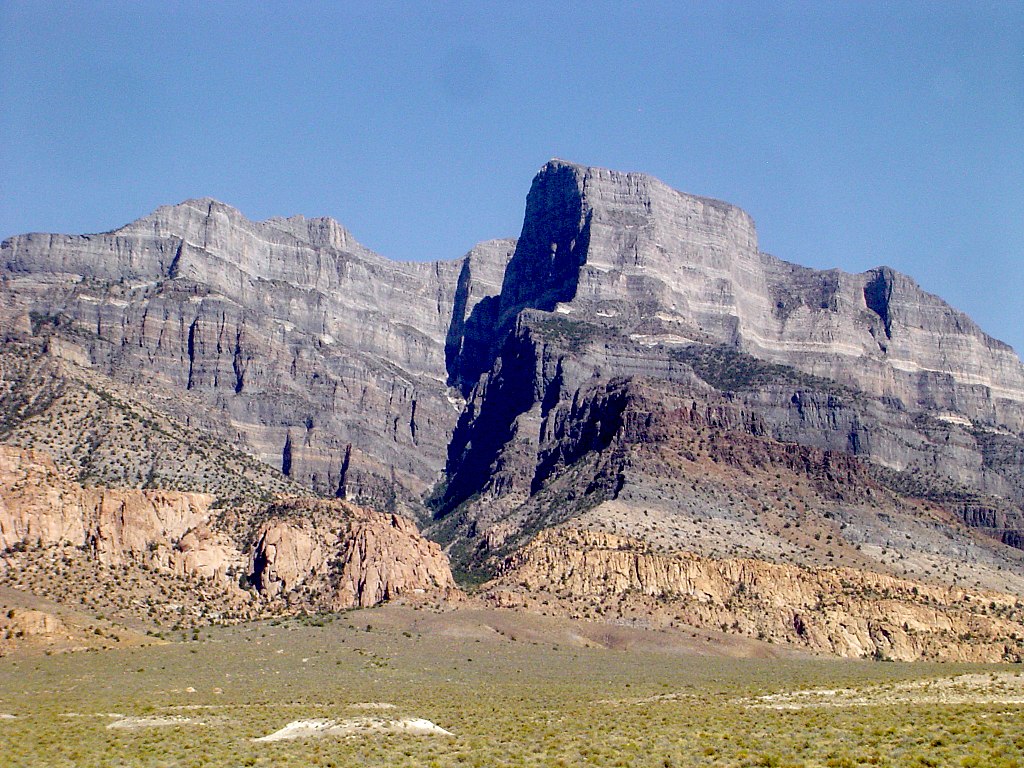 Pink monzonite laccolith intrudes within grey Cambrian and Ordovician strata near Notch Peak, Utah
